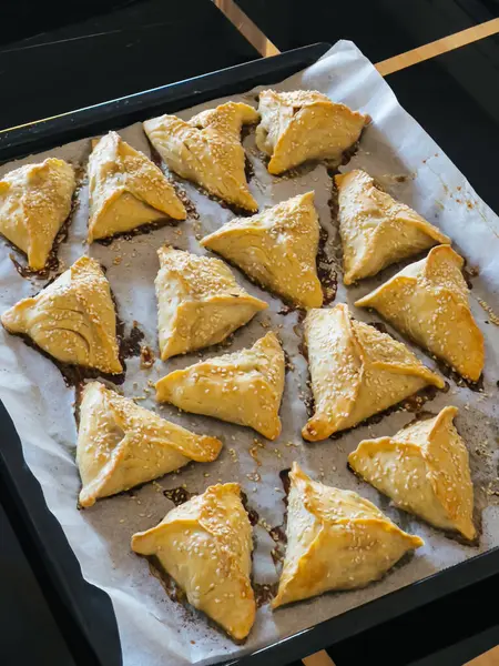 Masadaki tepside susam tohumlu üçgen puf böreği var. Yüksek kalite fotoğraf