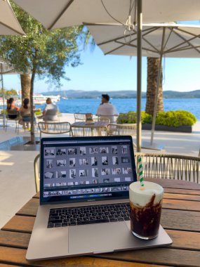 Milkshake bir sokak kafesindeki masada dizüstü bilgisayarda duruyor. Yüksek kalite fotoğraf