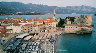 Deniz kıyısındaki eski Budva kasabasının taş kale duvarlarının yanındaki sahil. Karadağ. Drone. Yüksek kalite fotoğraf