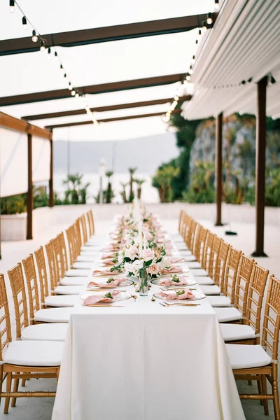 Meja Pesta Panjang Dengan Karangan Bunga Bawah Kanopi Taman Dikelilingi — Stok Foto