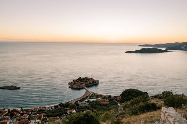 Dağdan Sveti Stefan adasına turuncu bir günbatımı gökyüzünün arka planına bak. Karadağ. Yüksek kalite fotoğraf