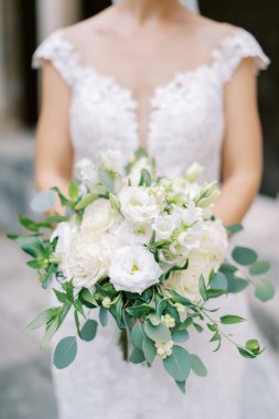 Gelinin elinde bir buket çiçek. Kırpılmış. Yüzsüz. Yüksek kalite fotoğraf
