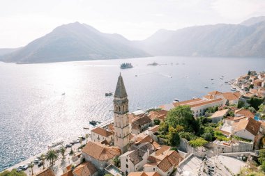Kotor Körfezi kıyısındaki antik evlerin kırmızı çatıları arasında yüksek çan kulesi. Perast, Karadağ. Drone. Yüksek kalite fotoğraf