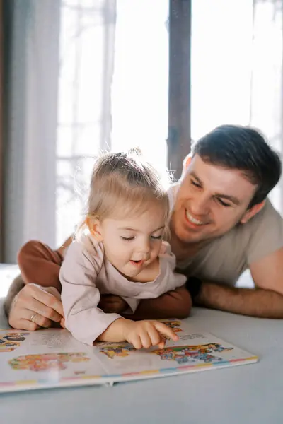Little Girl Shows Picture Book Fairy Tales Smiling Dad While Stock Image