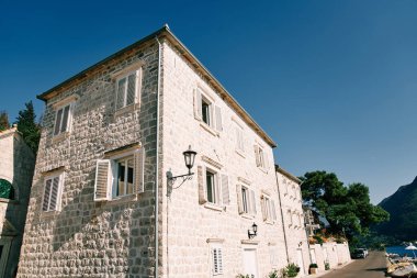 Deniz kıyısında açık beyaz panjurları olan eski taş evler. Perast, Karadağ. Yüksek kalite fotoğraf