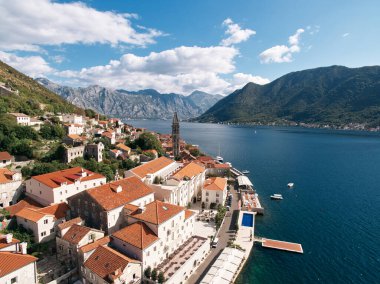 Kotor Körfezi 'nin kıyısında kırmızı çatıları olan ve gezinti alanında yüzme havuzu olan eski evler. Perast, Karadağ. Drone. Yüksek kalite fotoğraf