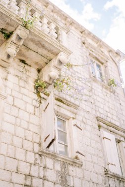 Eski bir taş evin camlarında beyaz ahşap panjurlar var. Yüksek kalite fotoğraf