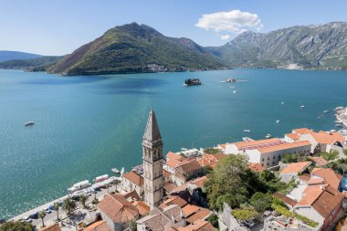 Aziz Niklas Kilisesi 'nin çan kulesi dağlara ve Kotor Körfezi' ne bakan kırmızı çatıların üstünde. Karadağ. Drone. Yüksek kalite fotoğraf