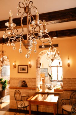 Bir restoranın tavanında asılı kristal kolyeli bronz avize. Yüksek kalite fotoğraf