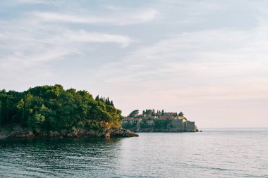 Kotor Körfezi 'ndeki Sveti Stefan adasındaki yeşil bir kıyı çıkıntısının arkasından bak. Karadağ. Yüksek kalite fotoğraf