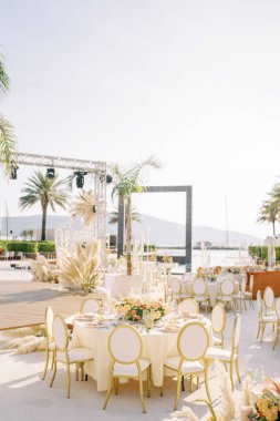 Yuvarlak servis masaları sahnenin yanında, güneşli terasta spot ışıkları var. Yüksek kalite fotoğraf