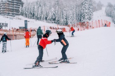 Kayakçılar dağ yamacında kayakçıların yanında el ele tutuşuyorlar. Yüksek kalite fotoğraf