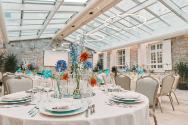 Tavanında parlak yuvarlak lambalar olan bir restorana çiçeklerle masalar yerleştirdim. Yüksek kalite fotoğraf