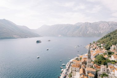 Kotor Körfezi 'ne bakan antik evlerin arasında yüksek çan kulesi olan Perast kıyısı. Karadağ. Drone. Yüksek kalite fotoğraf