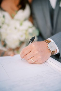 Damat evlilik cüzdanını imzalıyor. Kırpılmış. Yüzsüz. Yüksek kalite fotoğraf
