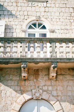 Antik bir evin balkonunda, kemerli kapının üzerinde armalı bir arma bulunan taş bir balkon. Yüksek kalite fotoğraf