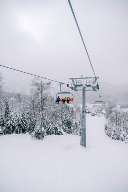 Kayakçılarla birlikte teleferik, Kolasin 1600 tatil beldesinde karlı bir yamaca yükseliyor. Karadağ. Yüksek kalite fotoğraf