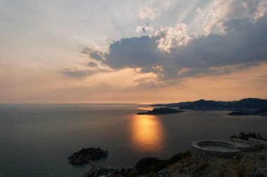 Dağlarda ve Sveti Stefan adasında turuncu gün batımı. Karadağ. Yüksek kalite fotoğraf