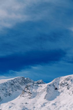 Mavi gökyüzünün arkaplanına karşı karlı dağlar. Yüksek kalite fotoğraf