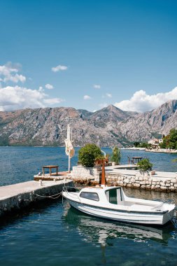 Eski bir kasabanın taş iskelesine demirlenmiş küçük bir tekne. Yüksek kalite fotoğraf