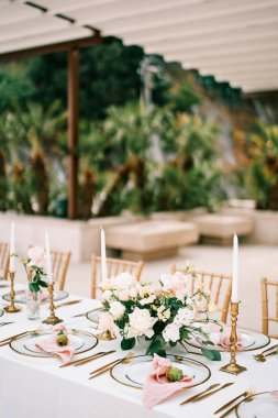 Çiçek buketleri, mumlar ve tabakta küçük narlar olan şölen masası. Yüksek kalite fotoğraf
