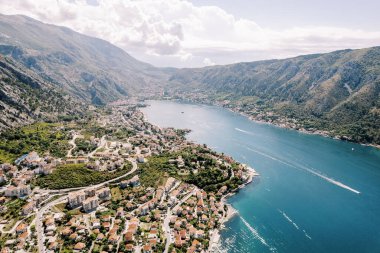 Dağların eteğindeki Kotor Körfezi kıyısındaki tatil köylerinin panoramik manzarası. Karadağ. Drone. Yüksek kalite fotoğraf