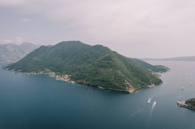 Yatlar Kotor Körfezi boyunca yeşil dağ sırasını geçerek yol alır. Hava görüntüsü. Yüksek kalite fotoğraf