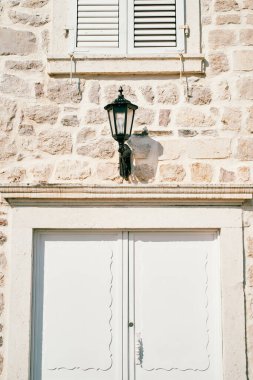 Girişteki eski bir evin taş cephesinde fener var. Yüksek kalite fotoğraf