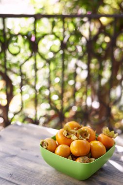 Dolu bir kase hurma, balkondaki ahşap bir masada duruyor. Yüksek kalite fotoğraf