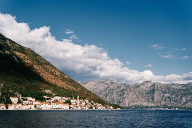 Kırmızı çatıları olan antik evler ve dağların eteğinde bir kilise çan kulesi. Perast, Karadağ. Yüksek kalite fotoğraf