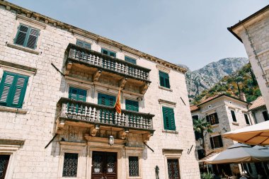 Karadağ bayrağı antik bir taş evin terasında bayrak direğine asıldı. Kotor. Yüksek kalite fotoğraf