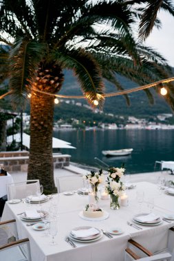 Şamdanların içinde yanan mumlar ve ortasında düğün pastası olan bir masa. Yüksek kalite fotoğraf