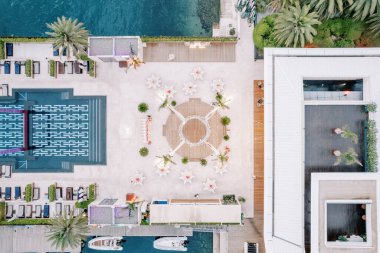 Yuvarlak ziyafet masaları, uzun havuz ile süslenmiş bir gölgelik sahnenin etrafını sarar. Üst Manzara. Yüksek kalite fotoğraf