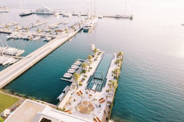 Parti masaları uzun bir iskelede duruyor. Yüzme havuzu ve yatlar kenarda demirli. Drone. Yüksek kalite fotoğraf