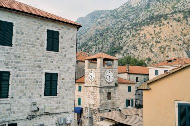 Meydandaki taş evlerin arasında antik saat kulesi. Kotor, Karadağ. Yüksek kalite fotoğraf