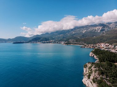 Kotor Körfezi 'nin yeşil kayalık kıyısı dağların eteklerindeki tatil köyüne bakıyor. Karadağ. Drone. Yüksek kalite fotoğraf
