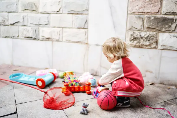 소녀는 맞서면서 다채로운 장난감으로 놀고있다 품질의 — 스톡 사진