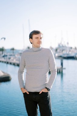 Elleri pantolonunun cebinde gülümseyen genç adam setin yanlamasına ayakta duruyor. Yüksek kalite fotoğraf