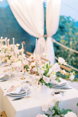 Bir buket çiçek bardakların ve tabakların yanındaki şenlik masasında duruyor. Yüksek kalite fotoğraf