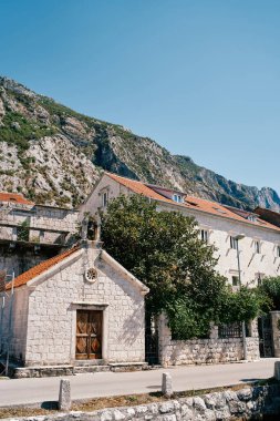 St. Michael 'daki küçük taş kilise kırmızı çatılı eski bir evin yanında. Dobrota, Karadağ. Yüksek kalite fotoğraf