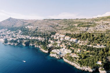 Yeşil ağaçların arasında kayalık bir sahildeki modern oteller. Dubrovnik, Hırvatistan. Drone. Yüksek kalite fotoğraf