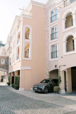 Siyah Mercedes Benz renkli bir otelin otoparkından ayrılıyor. Yüksek kalite fotoğraf