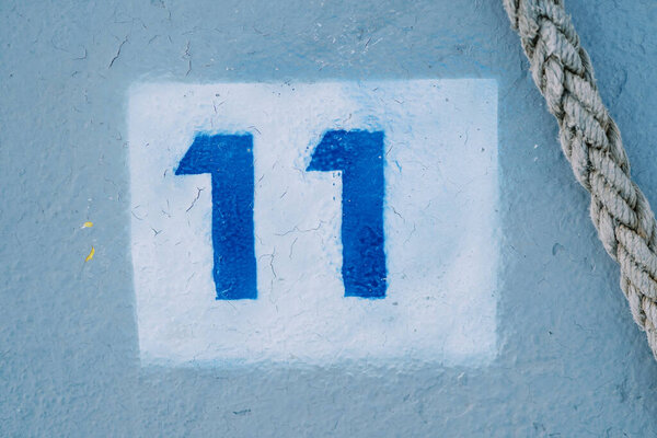 Rope lies near the drawn number eleven in a white rectangle on a blue floor. High quality photo — Stock Image Rope Lies Drawn Number Eleven White Rectangle Blue Floor High Stock Picture