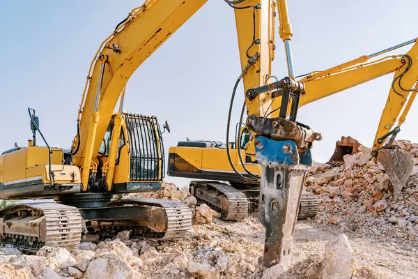 Sarı sürüngen kazıcı taş ocağında sondaj makinesinin yanında taş kazıyor. Yüksek kalite fotoğraf