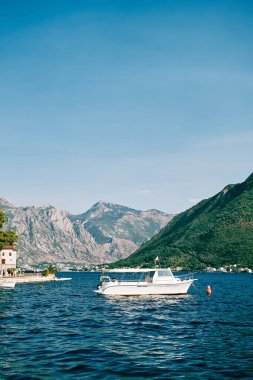 Gezi teknesi Perast sahilinin açıklarında, dağların arka planına demirlemiş durumda. Karadağ. Yüksek kalite fotoğraf