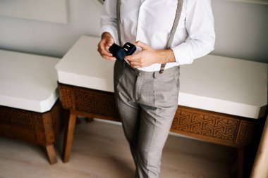 Damat, elinde alyanslarla masada duran açık bir kutu tutuyor. Kırpılmış. Yüzsüz. Yüksek kalite fotoğraf