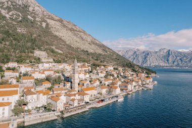Aziz Niklas Kilisesi 'nin çan kulesi deniz kıyısındaki antik evlerin kırmızı çatıları arasında. Perast, Karadağ. Yüksek kalite fotoğraf