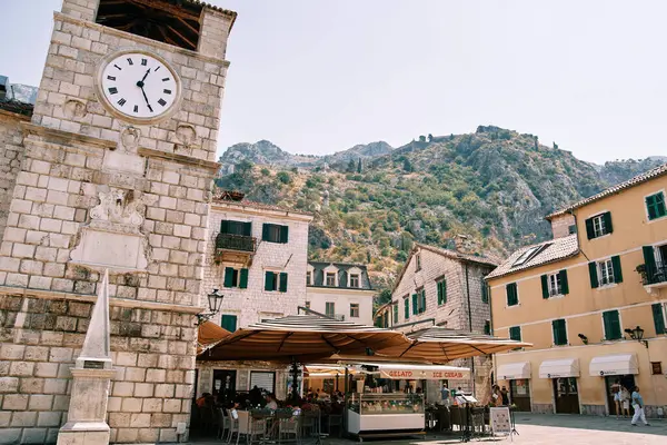 Sokak kafenin yanındaki meydanda antik saat kulesi. Kotor, Karadağ. Yüksek kalite fotoğraf