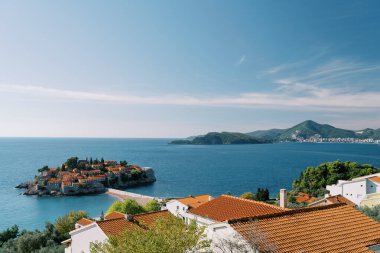 Kotor Körfezi 'ndeki Sveti Stefan adasının arka planında dağlar olan kırmızı çatılarına bakın. Karadağ. Yüksek kalite fotoğraf