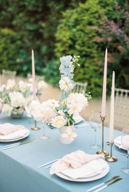 Düğümlü peçeteler sehpanın üzerindeki tabaklarda davetiyelerle yatar. Yüksek kalite fotoğraf